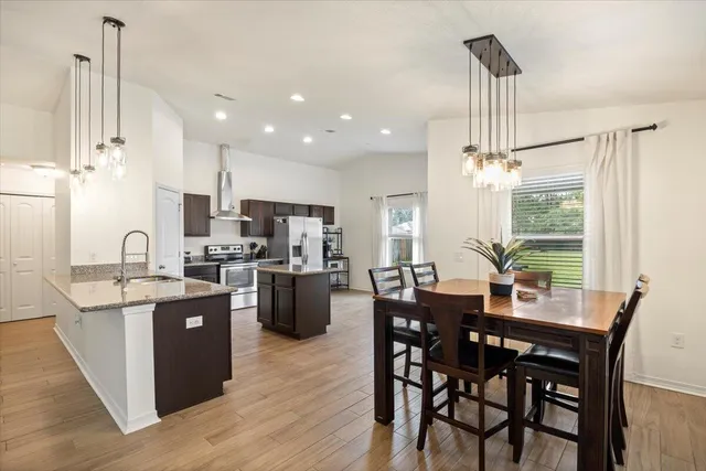 a view of a dining room and livingroom with furniture wooden floor a chandelier