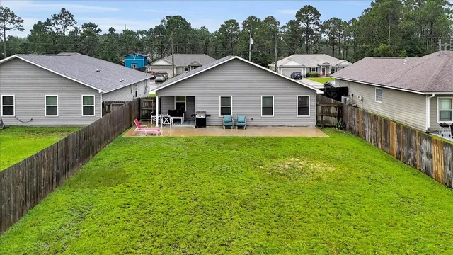 a view of a house with a yard and sitting area