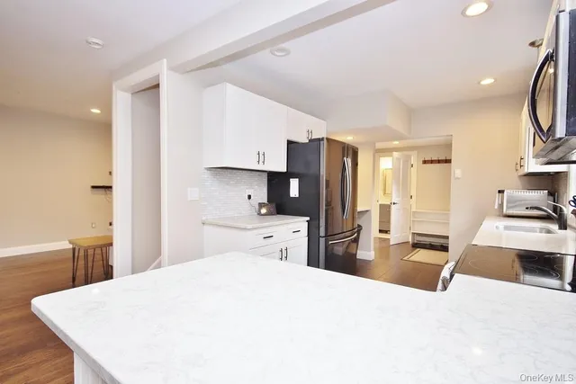 a large kitchen with a refrigerator a stove a sink dishwasher and wooden cabinets with wooden floor