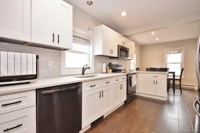 a kitchen with granite countertop white cabinets and white appliances
