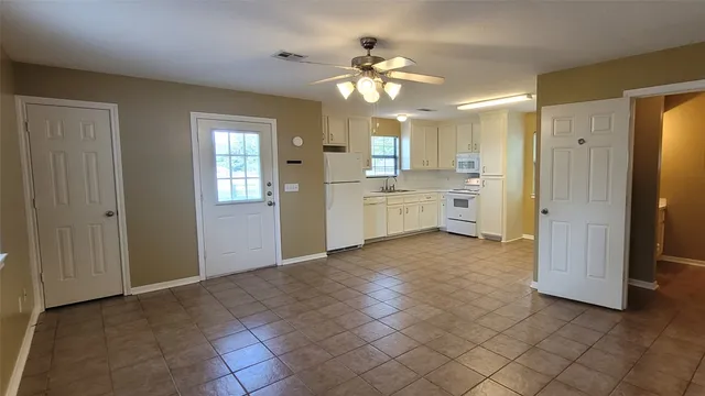 a kitchen with white cabinets and white appliances
