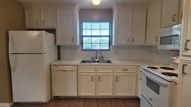 a kitchen with white cabinets and white appliances