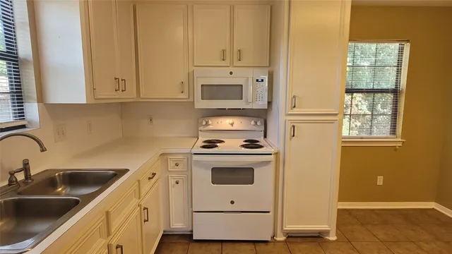 a view of a kitchen with white cabinets