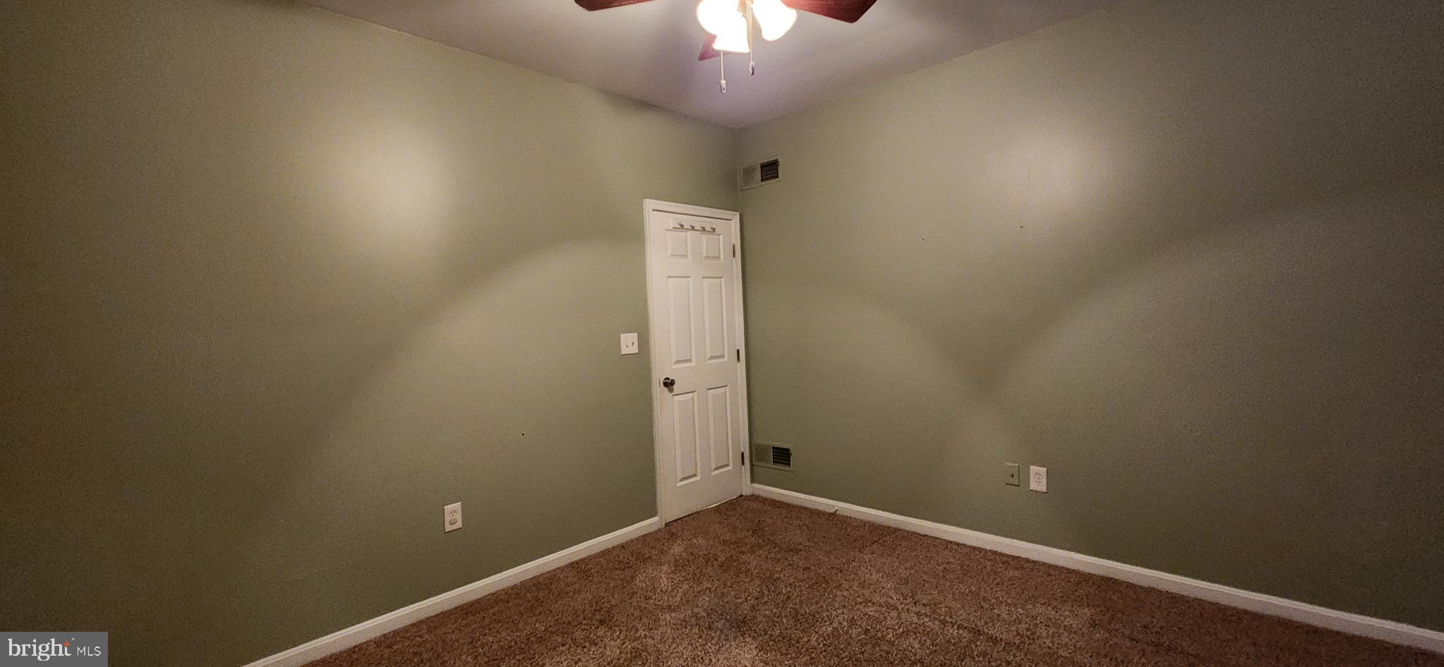 17010 Minos Conaway Road Lewes, DE 19958 - Photo 17 of 28 an empty room with a fan and a chandelier fan