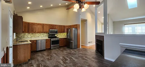 a kitchen with stainless steel appliances granite countertop a refrigerator and a stove top oven