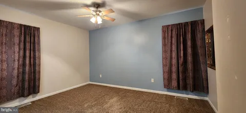 an empty room with closet and a chandelier fan
