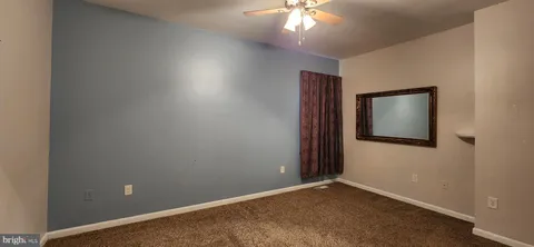 an empty room with a chandelier fan
