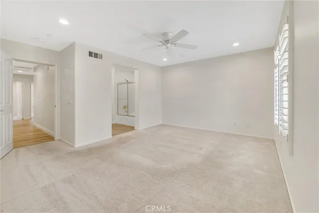 an empty room with fan and entrance