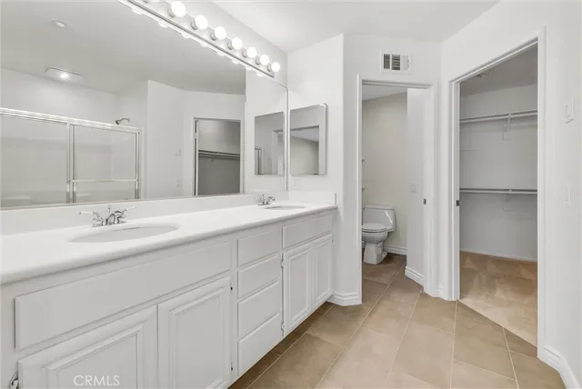 a bathroom with a double vanity sink mirror and toilet