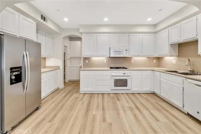 a kitchen with white cabinets stainless steel appliances and sink