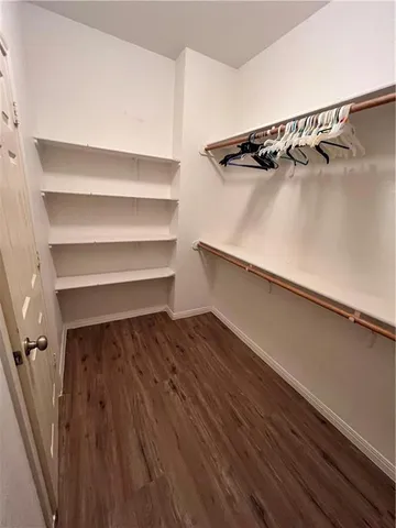 a view of walk in closet with empty racks