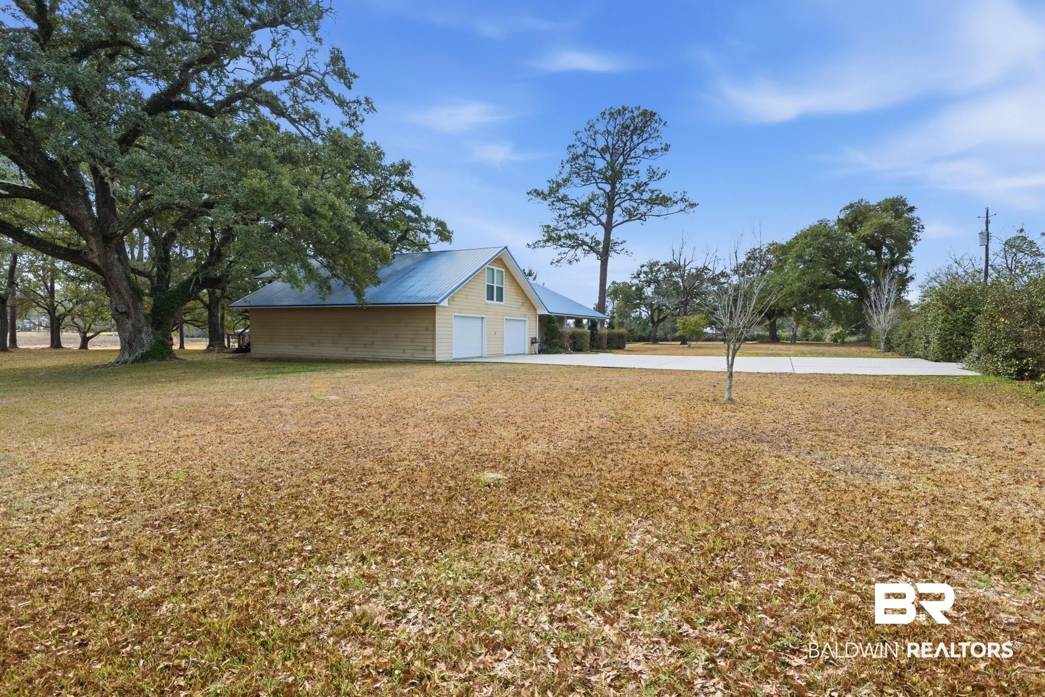 15025 Bellingrath Road Coden, AL 36523 - Photo 4 of 79 View of grassy yard with a garage and concrete driveway