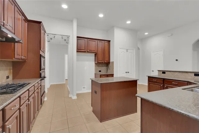 a kitchen with stainless steel appliances granite countertop a refrigerator and a stove