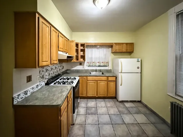 a kitchen with a sink a stove a refrigerator and a stove top oven