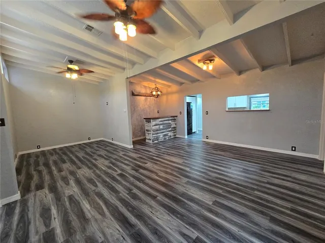 a view of a hallway with wooden floor and entryway