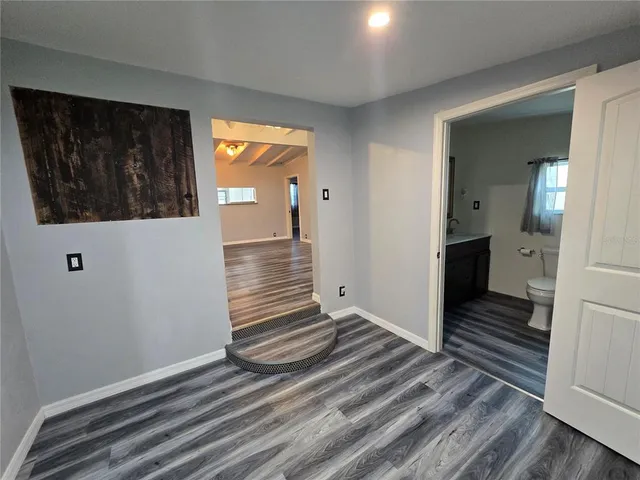 a view of a hallway with wooden floor and staircase