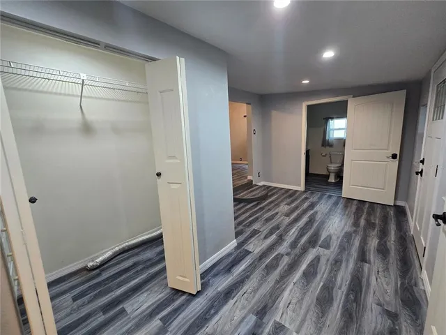 a view of a hallway with wooden floor and closet