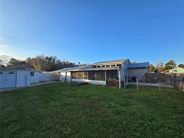 a view of a house with backyard and sitting area