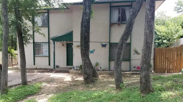 a view of a house with backyard and a tree