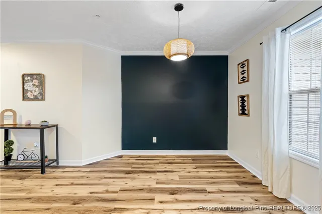 a view of a livingroom with wooden floor and a large window