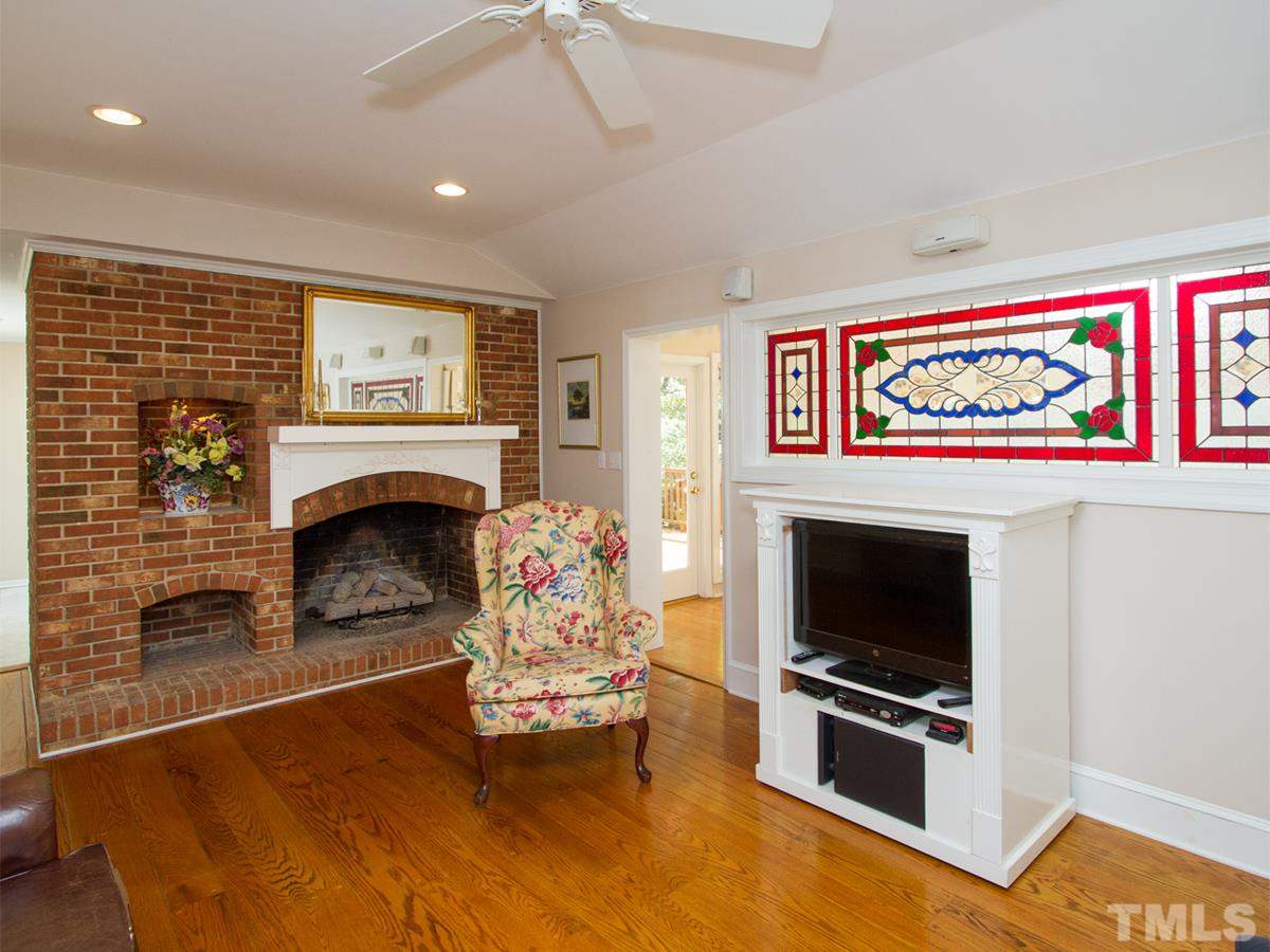 401 Sampson Street Raleigh, NC 27609 - Photo 8 of 25 a living room with furniture a flat screen tv and a fireplace