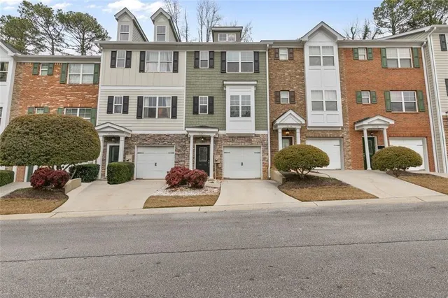 a view of a brick house with many windows and a yard