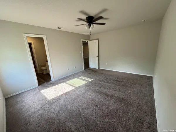 a view of an empty room with a ceiling fan