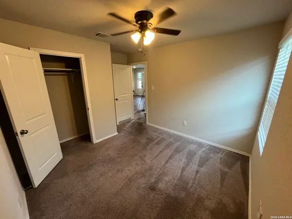 a view of a livingroom with a ceiling fan and window