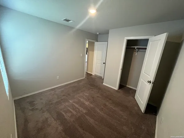 an empty room with closet and mirror