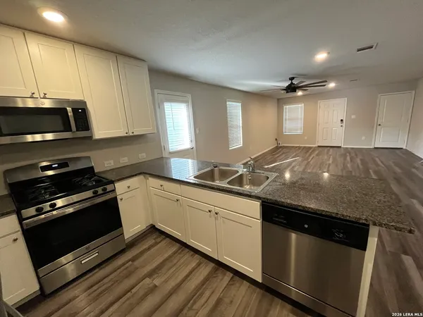 a kitchen with granite countertop a stove and a sink