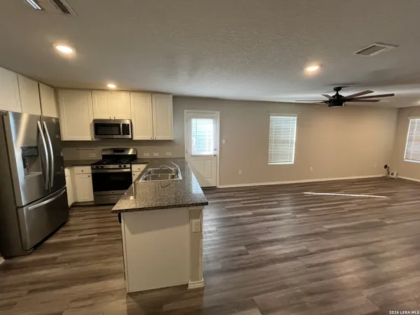 a kitchen with granite countertop a stove and a refrigerator