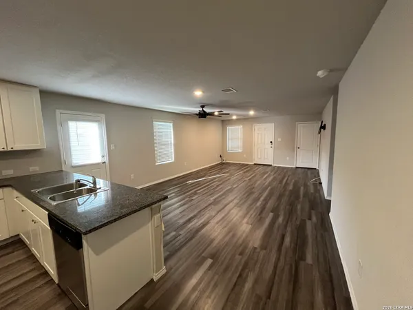 a kitchen with granite countertop a sink stove and cabinets