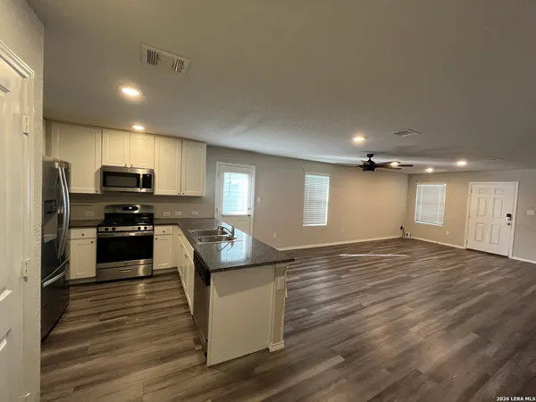 a kitchen with granite countertop a stove and refrigerator
