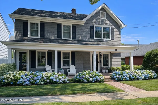 a front view of a house with a yard and plants