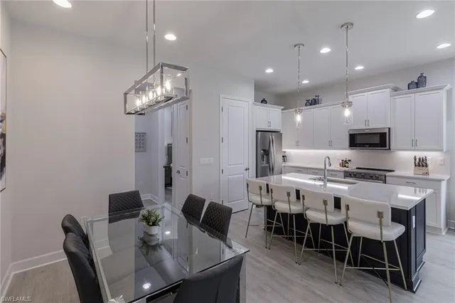 a view of a dining room with furniture a chandelier and wooden floor
