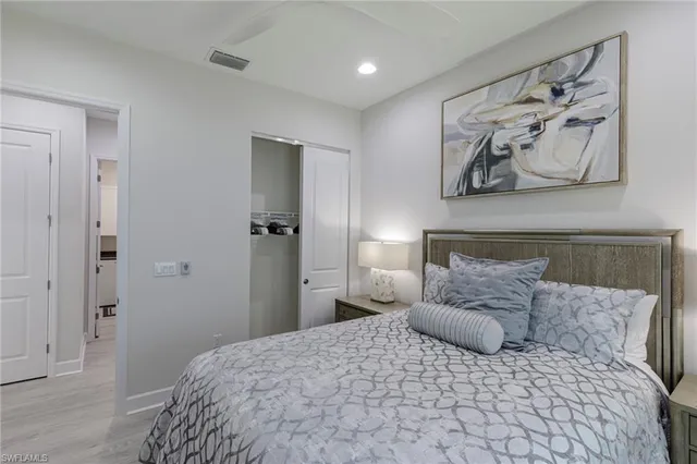 a large bedroom with a bed and painting on the wall