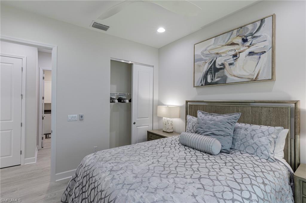 7138 Cayo Coco Lane Naples, FL 34113 - Photo 13 of 42 a large bedroom with a bed and painting on the wall