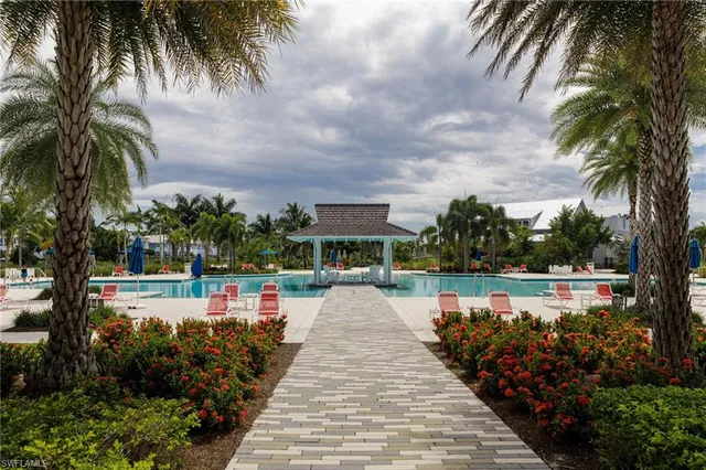 a view of a swimming pool with a lawn chairs under an umbrella