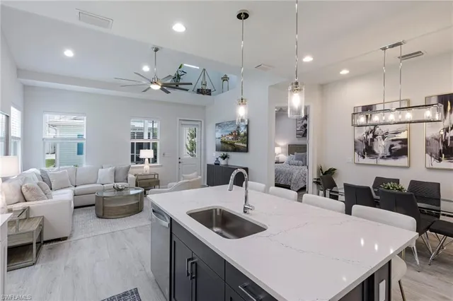 a kitchen with a dining table chairs sink and white cabinets