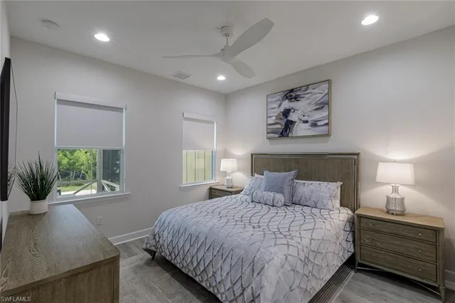 a bedroom with a large bed and a potted plant