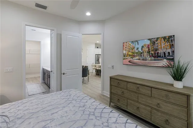 a spacious bedroom with a bed and a dresser in it