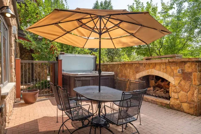 a patio with a table and chairs under an umbrella