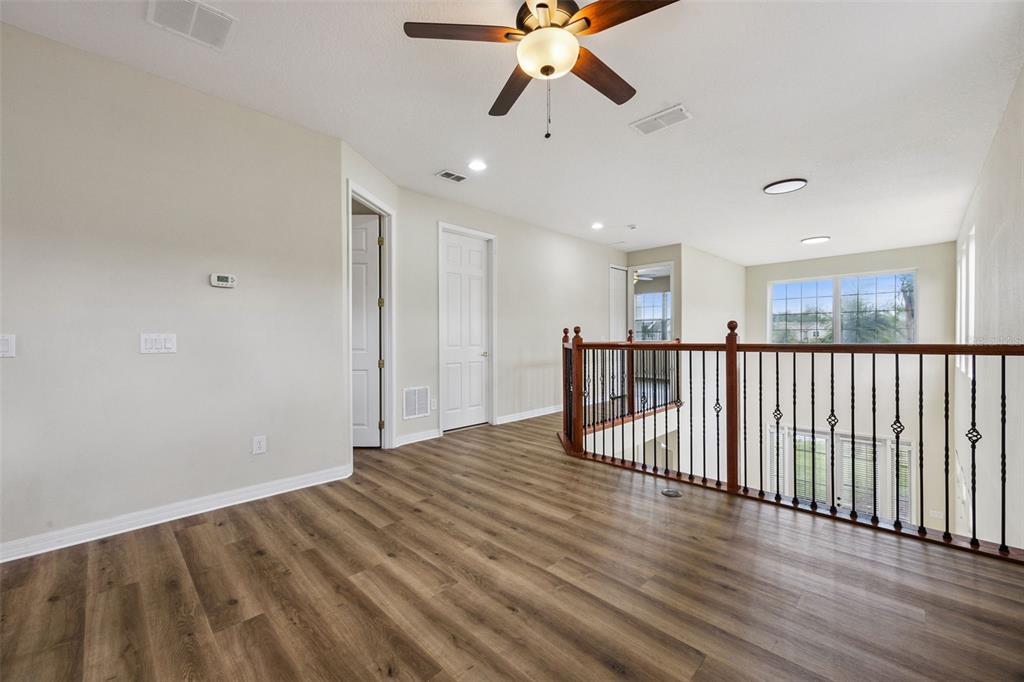 551 Terrace Spring Drive Orlando, FL 32828 - Photo 21 of 41 an empty room with wooden floor fan and windows