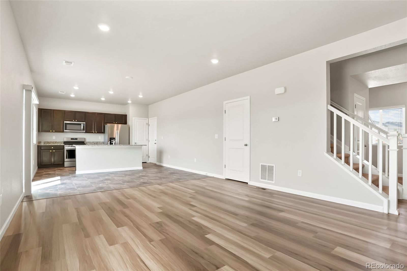 1843 Homestead Drive Fort Lupton, CO 80621 - Photo 15 of 33 a view of an empty room with wooden floor