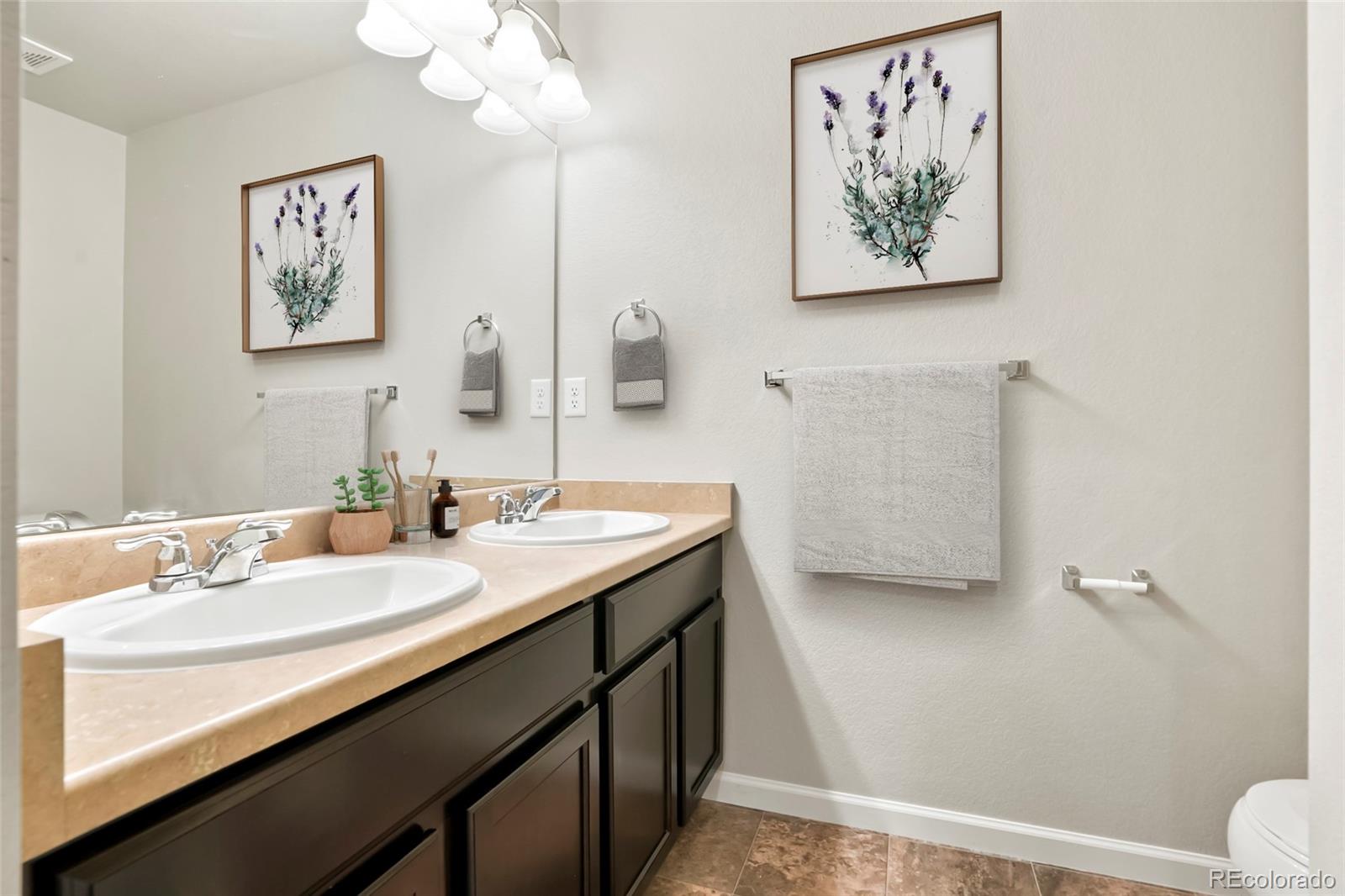 1843 Homestead Drive Fort Lupton, CO 80621 - Photo 8 of 33 a en suite bathroom with a granite countertop sink a toilet and a mirror