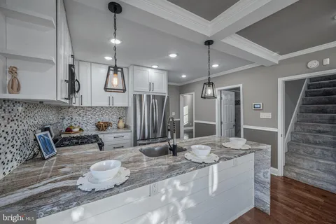 a kitchen with granite countertop a sink and a refrigerator