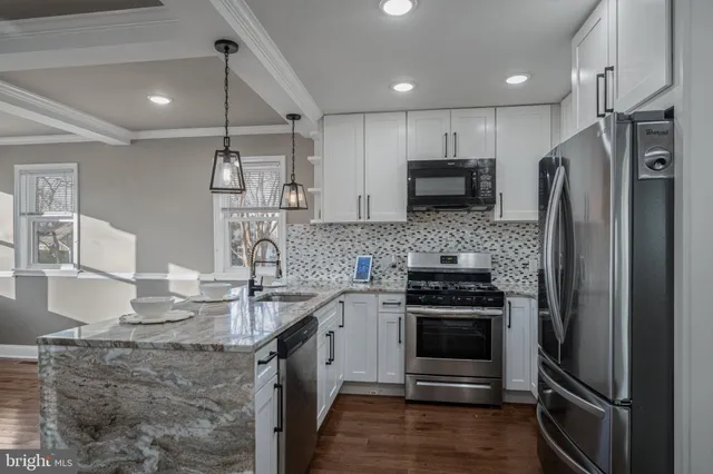 a kitchen with kitchen island granite countertop stainless steel appliances and a counter top space
