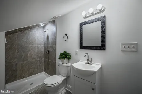a bathroom with a toilet a sink and mirror