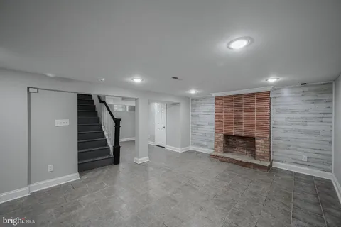 an empty room with a fireplace and stairs