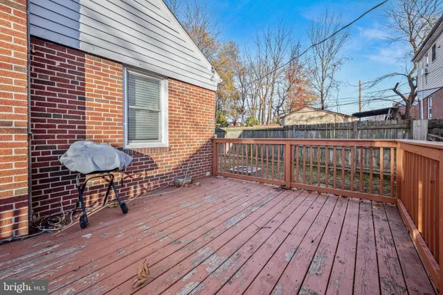 a view of a deck with wooden floor and fence next to a yard